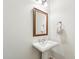 A pedestal sink with faucet, mirror, and towel ring adorn this simply decorated powder room at 17727 N 95Th Pl, Scottsdale, AZ 85255