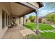 Inviting covered patio with comfortable seating, overlooking a lush green lawn and manicured landscaping at 17727 N 95Th Pl, Scottsdale, AZ 85255