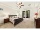 Relaxing bedroom features a ceiling fan, large windows with shutters, and neutral color palette at 17727 N 95Th Pl, Scottsdale, AZ 85255