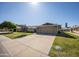 Inviting home featuring a well-kept lawn, mature landscaping, and attached two-car garage at 18835 N Mayan Dr, Sun City, AZ 85373