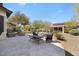 Spacious backyard featuring a stone patio, desert landscaping, and comfortable seating area under the clear blue sky at 21232 N 262Nd Dr, Buckeye, AZ 85396