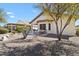 Rear exterior showcasing a covered patio, desert landscaping, and outdoor seating areas with mature trees at 21232 N 262Nd Dr, Buckeye, AZ 85396