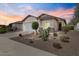 Charming single-story home featuring desert landscaping, a two-car garage, and warm exterior lighting at 21232 N 262Nd Dr, Buckeye, AZ 85396