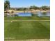 Scenic view of golf course overlooking a pond with green fairways and desert landscapes at 21232 N 262Nd Dr, Buckeye, AZ 85396