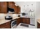 Modern kitchen with stainless steel appliances, granite countertops, and open to the living area at 21232 N 262Nd Dr, Buckeye, AZ 85396