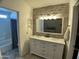 Bright bathroom featuring double sinks, a stone accent wall and a view into the bedroom at 24809 N 41 Ave, Glendale, AZ 85310