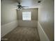 A cozy bedroom with paneled walls, plush carpet, and a bright window at 24809 N 41 Ave, Glendale, AZ 85310