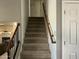 Carpeted staircase with wooden handrail provides access to the upper level of the house at 24809 N 41 Ave, Glendale, AZ 85310