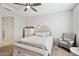 This bedroom features a ceiling fan, dresser, and a comfortable chair with a 'Gathering' pillow at 25451 N 164Th Dr, Surprise, AZ 85387