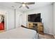 Bedroom with a full-size bed, ceiling fan, and television with a wooden entertainment center at 25451 N 164Th Dr, Surprise, AZ 85387