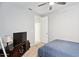 Neutral bedroom with ceiling fan, tv, dresser, and a door to the bathroom at 25451 N 164Th Dr, Surprise, AZ 85387