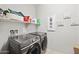 Well-organized laundry room featuring front loading washer and dryer with overhead shelving at 25451 N 164Th Dr, Surprise, AZ 85387