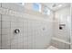 The walk-in shower features white tile, mosaic accents, and natural light from high windows at 25451 N 164Th Dr, Surprise, AZ 85387