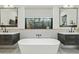 Modern bathroom features double vanities, soaking tub, and a large window at 3530 E Glenrosa Ave, Phoenix, AZ 85018