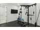 Home gym with full weight rack, TV, rubber flooring, and bench for a complete workout space at 3530 E Glenrosa Ave, Phoenix, AZ 85018