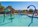 Community pool area featuring splash pad with vibrant, playful water features, seating, and well-maintained landscaping at 3890 S Star Canyon Dr, Gilbert, AZ 85297