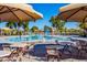 Resort-style community pool featuring splash pad, lounge chairs, shaded tables, and vibrant landscaping under a clear blue sky at 3890 S Star Canyon Dr, Gilbert, AZ 85297