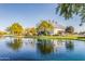 Scenic view of the Ranch House Clubhouse building surrounded by a pond, green landscaping, and beautiful trees at 3890 S Star Canyon Dr, Gilbert, AZ 85297