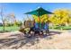 Community playground with colorful play structure, slide, climbing features, shade structure, and a grassy area at 3890 S Star Canyon Dr, Gilbert, AZ 85297