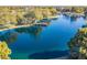 Aerial view of pond with a pier, surrounded by lush trees, showcasing the beauty of the community at 3890 S Star Canyon Dr, Gilbert, AZ 85297