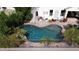 Aerial shot of a kidney-shaped pool with brick trim, surrounded by plants and a white house with flower pots at 3890 S Star Canyon Dr, Gilbert, AZ 85297