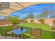 Inviting backyard with artificial turf, desert landscaping, and a covered patio, perfect for relaxing and entertaining at 4718 E Mossman Rd, Phoenix, AZ 85050