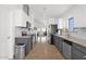 Bright kitchen with stainless steel appliances, grey cabinets, and a view into the living room at 4718 E Mossman Rd, Phoenix, AZ 85050