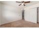 Bedroom with ceiling fan, closet and neutral colored walls and carpet at 6534 S Marilyn Ann Dr, Tempe, AZ 85283