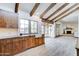 Spacious kitchen featuring wooden beams, ample cabinetry, granite counters, and white ceramic farmhouse sink at 6915 E Gary Rd, Scottsdale, AZ 85254