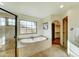 Bright main bathroom featuring a jetted tub, tiled shower, tiled floors, and walk-in closet at 6915 E Gary Rd, Scottsdale, AZ 85254