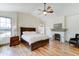 Cozy main bedroom with fireplace, ceiling fan, wood floors, and abundant natural light at 6915 E Gary Rd, Scottsdale, AZ 85254