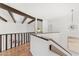 Hallway with modern chandelier, wooden floors, dark wood railing and beams, and white walls at 7209 E Mcdonald Dr # 51, Scottsdale, AZ 85250