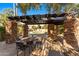 Relaxing poolside patio area with stone pillars and shade structure, creating an inviting outdoor space at 7209 E Mcdonald Dr # 51, Scottsdale, AZ 85250