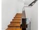 Wooden staircase in a modern home featuring stained wood steps, a dark handrail and white walls at 7209 E Mcdonald Dr # 51, Scottsdale, AZ 85250