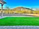 Beautiful backyard featuring synthetic grass, mountain views, and a pergola-covered patio perfect for entertaining at 7576 W Fetlock Trl, Peoria, AZ 85383