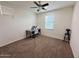 Neutral bedroom featuring a ceiling fan, plush carpeting, and a workspace by the window at 7576 W Fetlock Trl, Peoria, AZ 85383