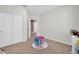 Neutral toned bedroom showcasing carpeted floors, a closet with sliding doors, and a charming table and chairs at 7576 W Fetlock Trl, Peoria, AZ 85383