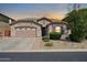 Inviting single-story home featuring a two-car garage and desert landscaping, with a warm color scheme at 7576 W Fetlock Trl, Peoria, AZ 85383