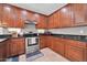 Kitchen with dark granite countertops, stainless steel appliances, and ample cherry-wood cabinetry at 7576 W Fetlock Trl, Peoria, AZ 85383