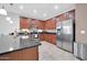 Open kitchen featuring dark granite countertops, stainless steel appliances, and ample cherry-wood cabinetry at 7576 W Fetlock Trl, Peoria, AZ 85383