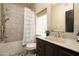 Bathroom featuring tiled shower-tub combo and stylish vanity with dark wood cabinetry at 8233 E Foothill Cir, Scottsdale, AZ 85255