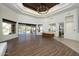 Spacious living room with wood tile flooring, pool access, and recessed ceiling with a chandelier at 8233 E Foothill Cir, Scottsdale, AZ 85255