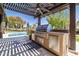 Covered outdoor kitchen with a built-in grill, counter space, and view of the swimming pool at 8233 E Foothill Cir, Scottsdale, AZ 85255