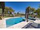 Backyard pool surrounded by pavers and lush landscaping, with mature trees in the distance at 8233 E Foothill Cir, Scottsdale, AZ 85255