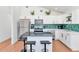 Bright kitchen featuring white cabinets, island with seating, stainless steel appliances, and decorative green tile backsplash at 92 N Palm St, Gilbert, AZ 85234