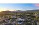 Aerial view showcasing the neighborhood and architecture of this home nestled in desert landscape with majestic mountain backdrops at 10354 E Celestial Dr, Scottsdale, AZ 85262