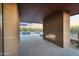 A covered patio with an outdoor fireplace, pool, and desert landscaping at 10354 E Celestial Dr, Scottsdale, AZ 85262