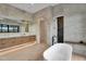 Elegant bathroom featuring soaker tub, wood cabinets, and marble countertops at 10354 E Celestial Dr, Scottsdale, AZ 85262