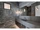 Modern bathroom featuring marble walls, floating vanity, and stylish pendant lighting at 10354 E Celestial Dr, Scottsdale, AZ 85262