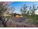 Modern desert home surrounded by lush trees and native plants with a neutral color palette at 10354 E Celestial Dr, Scottsdale, AZ 85262